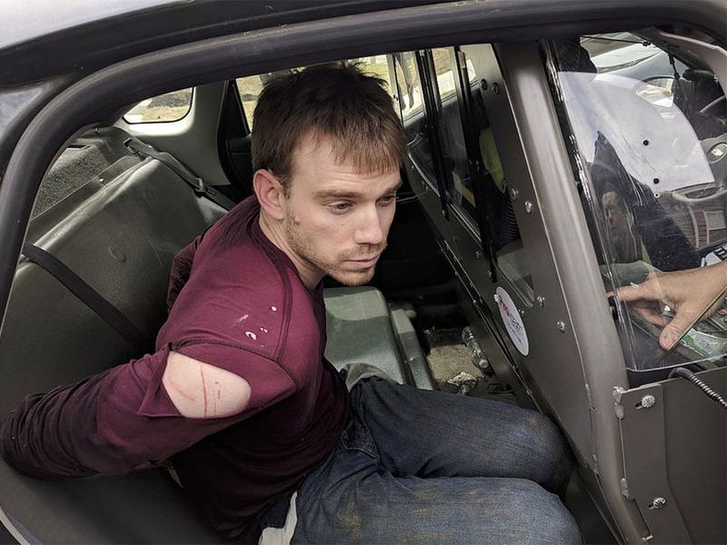 In this photo released by the Metro Nashville Police Department , Travis Reinking sits in a police car after being arrested in Nashville , Tenn. (AP)