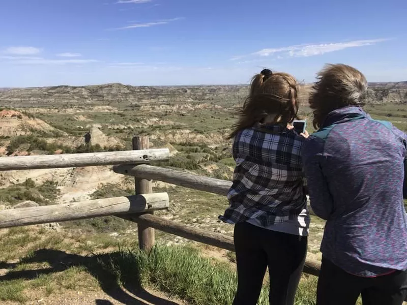 Jeanne Randall, right, and her daughter Zoe, of Shoreview, Minn., take
photos at Painted Canyon in Theodore Roosevelt National Park in western
North Dakota.