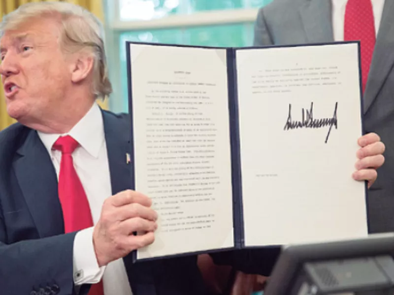 PresiDenT Donald trump holds up the executive order he signed to end family separations at the border. (AP)