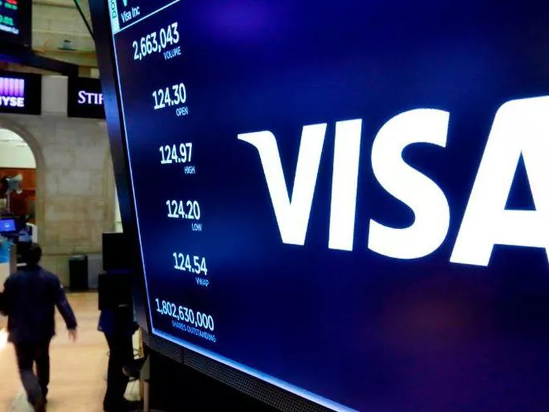 In this April 23, 2018, file photo, the logo for Visa appears above a trading post on the floor of the New York Stock Exchange.