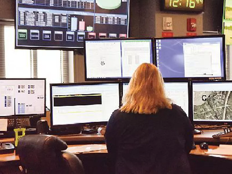 Adispatcher works at a desk station with a variety of screens used by those who take 911 emergency calls in Roswell, Ga.