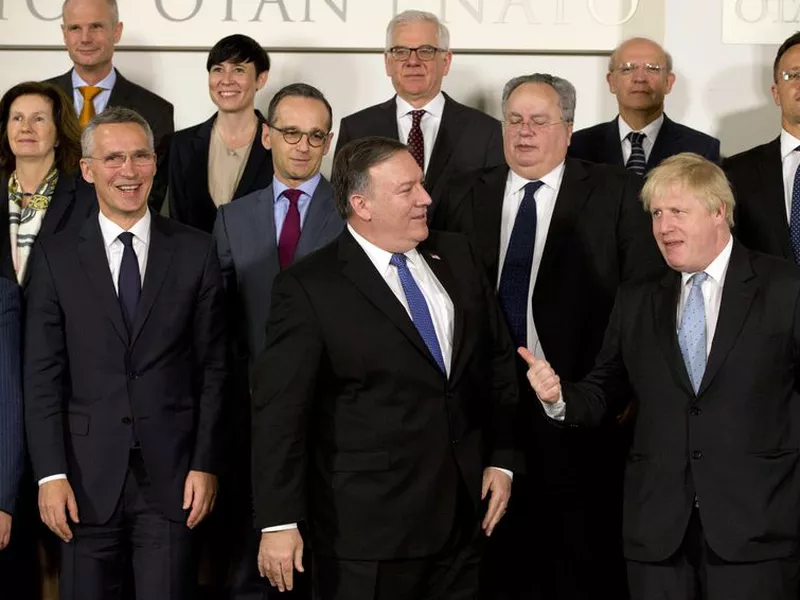 Mike Pompeo, front center, speaks with British Foreign Secretary Boris Johnson, front right, prior to a group photo of NATO. (AP)