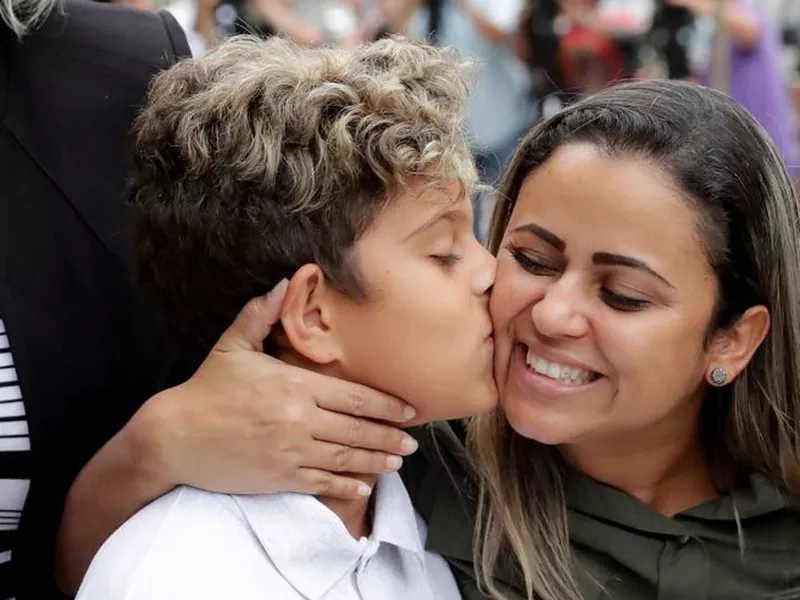 Diego Magalhaes, left, 10, kisses his mother Sirley Silveira, Paixao, an immigrant from Brazil seeking asylum with her son. (AP)