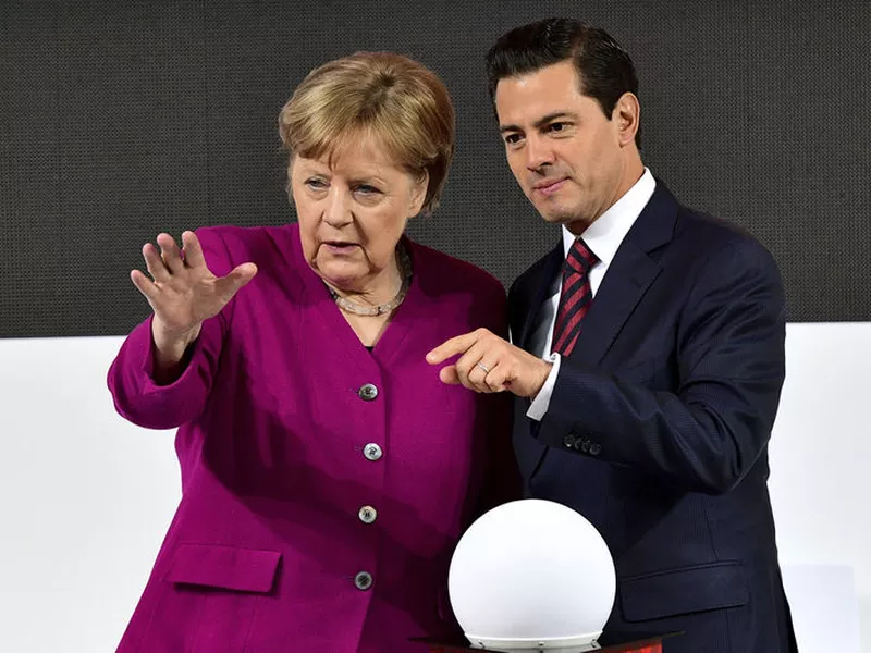 German Chancellor Angela Merkel, left, and Mexican President Enrique Pena Nieto chat as they tour the Hannover Messe fair where Mexico is this year’s guest country in Hannover, northern Germany.