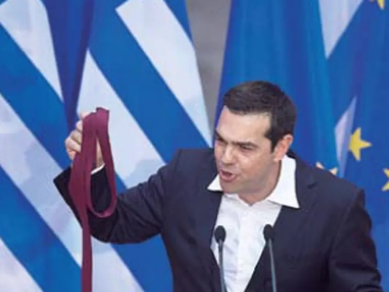 Greek Prime Minister Alexis Tsipras hold a tie he just removed his at the end of a speech to lawmakers. (AP)