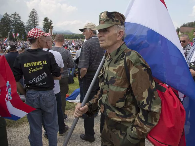 A uniformed man carries a Croatian flag during a commemoration ceremony in Bleiburg, Austria.