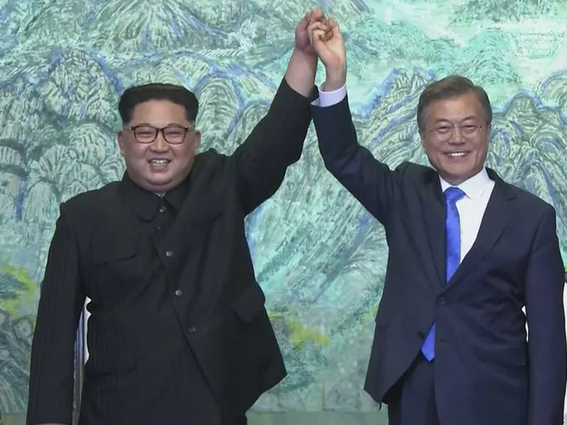 North Korean leader Kim Jong Un, left, and South Korean President Moon Jae-in raise their hands after signing on a joint statement at the border village of Panmunjom in the Demilitarized Zone. (AP)