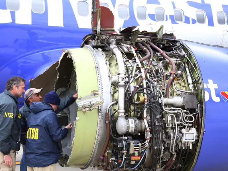 National Transportation Safety Board investigators examine damage to the engine of the Southwest Airlines plane that made an emergency landing at Philadelphia International Airport.