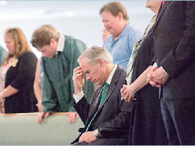 The Texas Gov. Greg Abbott joins a congregation in prayer at the Arcadia First Baptist Church, after a school shooting at Santa Fe High School on Friday, in Santa Fe, Texas.