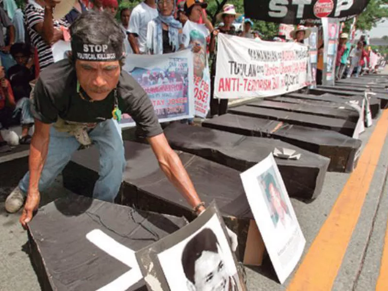 A man arranges mock coffins symbolizing the number of their companions killed or abducted, allegedly by the military. (AP)
