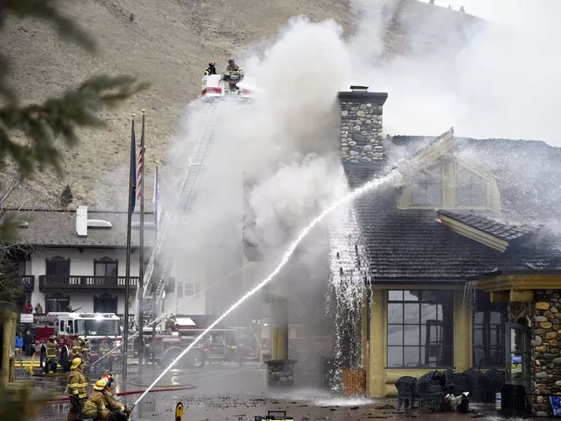 Firefighters work to extinguish a blaze that heavily damaged the Warm Springs Lodge. (AP)