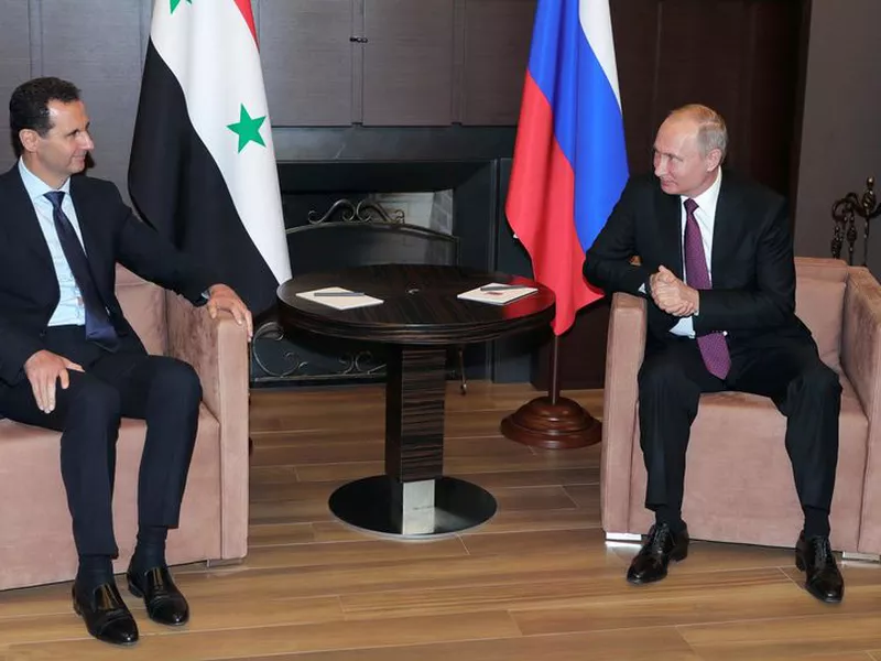 Russian President Vladimir Putin, right, listens to Syrian President Bashar al-Assad during their meeting in the Black Sea resort of Sochi, Russia.