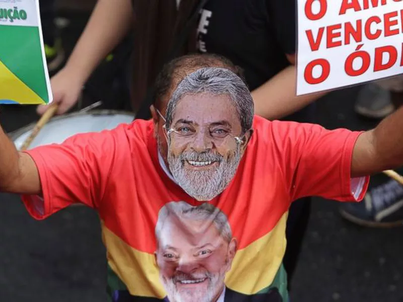 A demonstrator wearing a mask depicting former Brazilian President Luiz Inacio Lula da Silva.