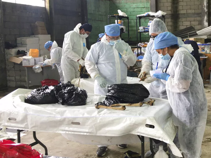 Forensic workers examine the remains of a victim of the Volcan de Fuego
eruption.