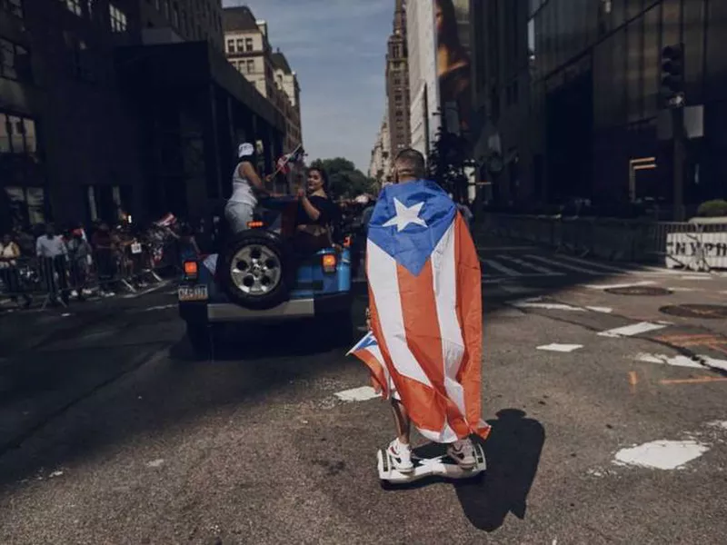 In this june 11, 2017 file photo, a man rolls on a hover-board along Fifth Avenue during the National Puerto Rican Day Parade in New York.