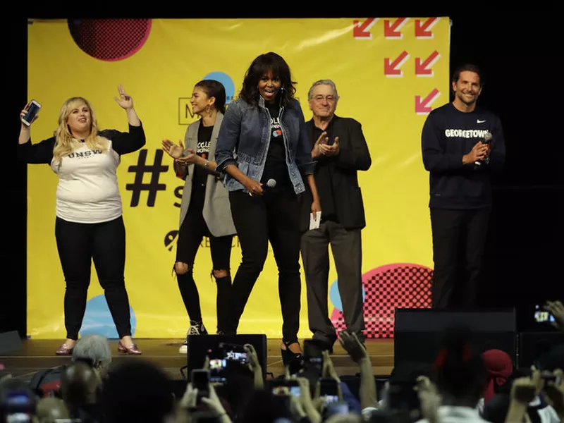 Michelle Obama, center, appears on stage as Rebel Wilson, background from left, Zendaya, Robert De Niro and Bradley Cooper look on at College Signing Day. (AP)