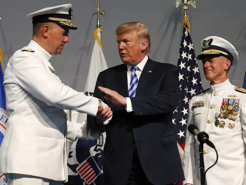 President Donald Trump, center, shakes hands with Coast Guard Adm. Karl Schultz, left. Trump says he wouldn’t mind seeing the North American Free Trade Agreement replaced by two separate, bilateral trade deals with Canada and Mexico.