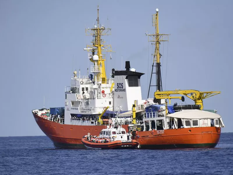 An Italian Coast Guard boat approaches the French NGO “SOS Mediterranee” Aquarius ship as migrants are being transferred, in the Mediterranean Sea. (AP)