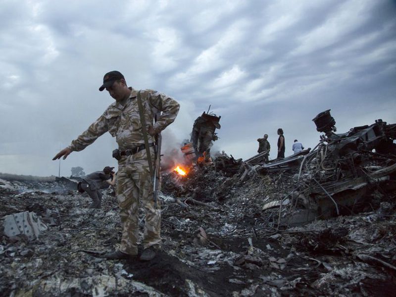 In this July 17, 2014 file photo, people walk amongst the debris at the crash site of a passenger plane near the village of Grabovo, Ukraine. (AP)