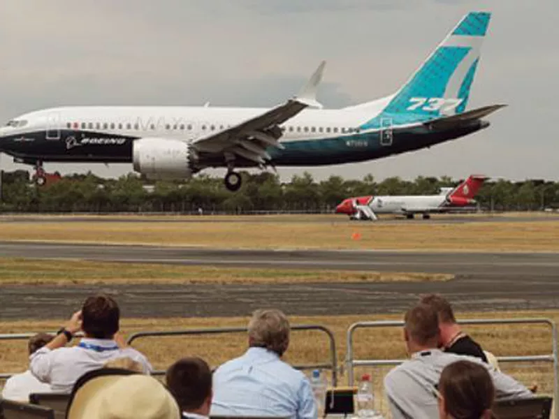 Spectators watch a Boeing 737 land after a flying display at the Farnborough Airshow in Farnborough, England. (AP)