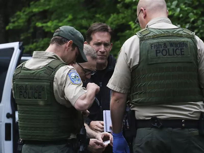 Washington State Fish and Wildlife Police confer with an individual, following
a fatal cougar attack.