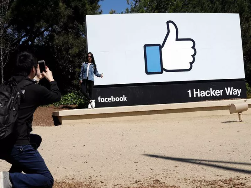 Visitors take photos in front of the Facebook logo at the company’s headquarters in Menlo Park, California. (AP)