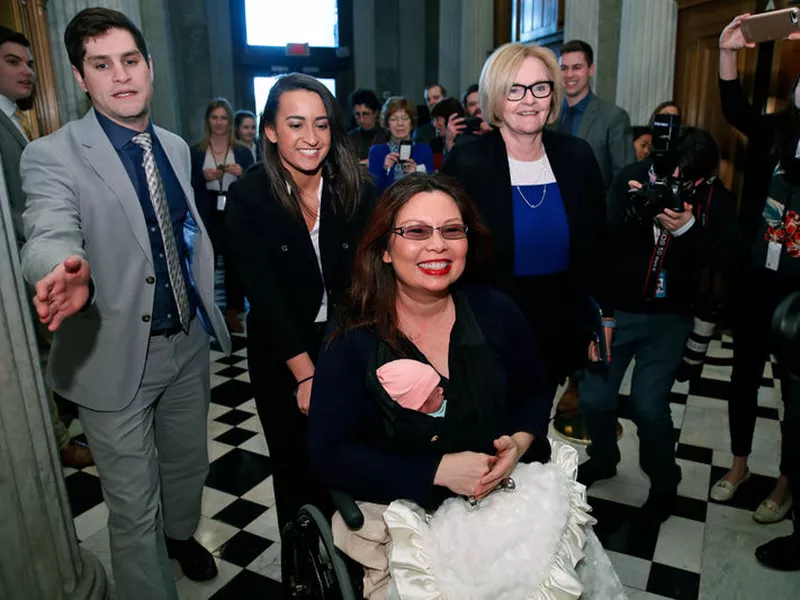 Tammy Duckworth, D-Ill., carries her baby Maile Pearl Bowlsbey as she heads to the Senate floor to vote, with Sen. Claire McCaskill, D-Mo., at right, on Capitol Hill.