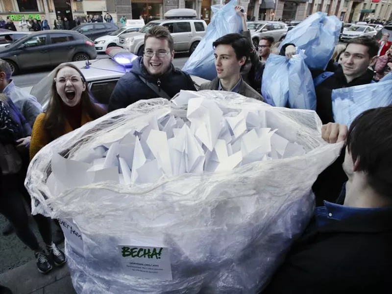Activists bring a sack with about 2,000 paper airplanes symbolising the logo of the messaging app Telegram to the door of St. Petersburg’s department of Roskomnadzor, in St. Petersburg, Russia. (AP)