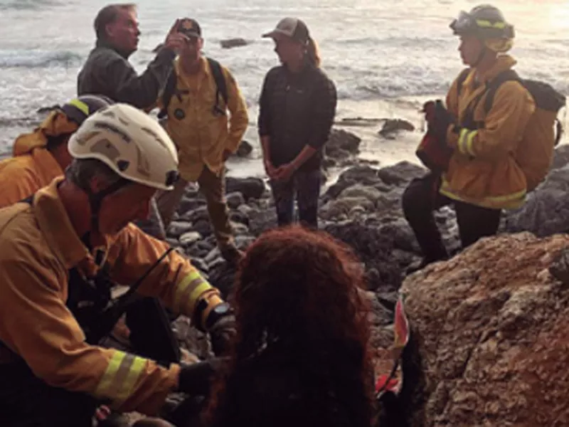 Authorities tend to Angela Hernandez, foreground center, after she was rescued, in Morro Bay, Calif.