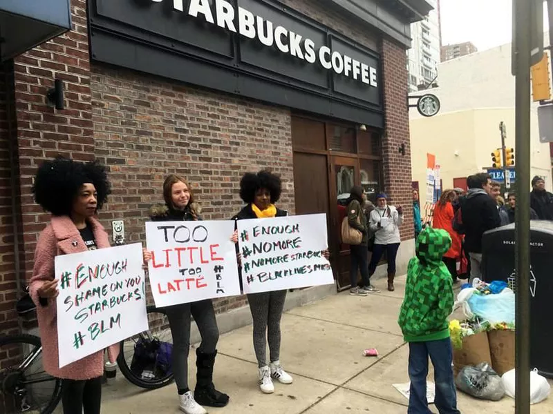 Demonstrators protest outside the Starbucks cafe in Philadelphia where two black men were arrested.