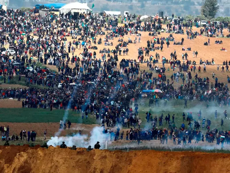 Teargas canisters fired by Israeli troops fall over Palestinian. (Reuters)