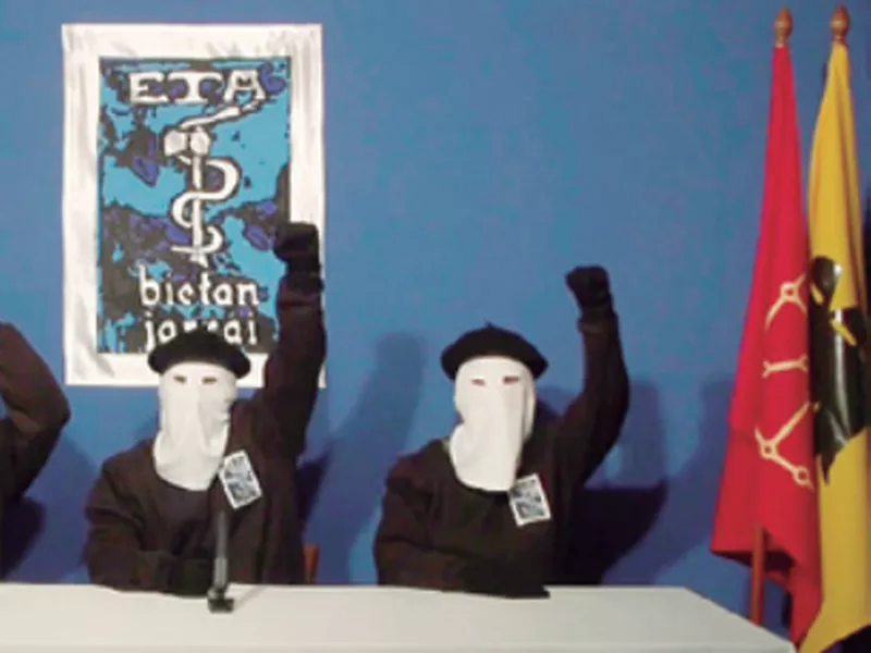 Masked members of the Basque separatist group
ETA raise their fists in unison following a news conference
at an undisclosed location. (AP).