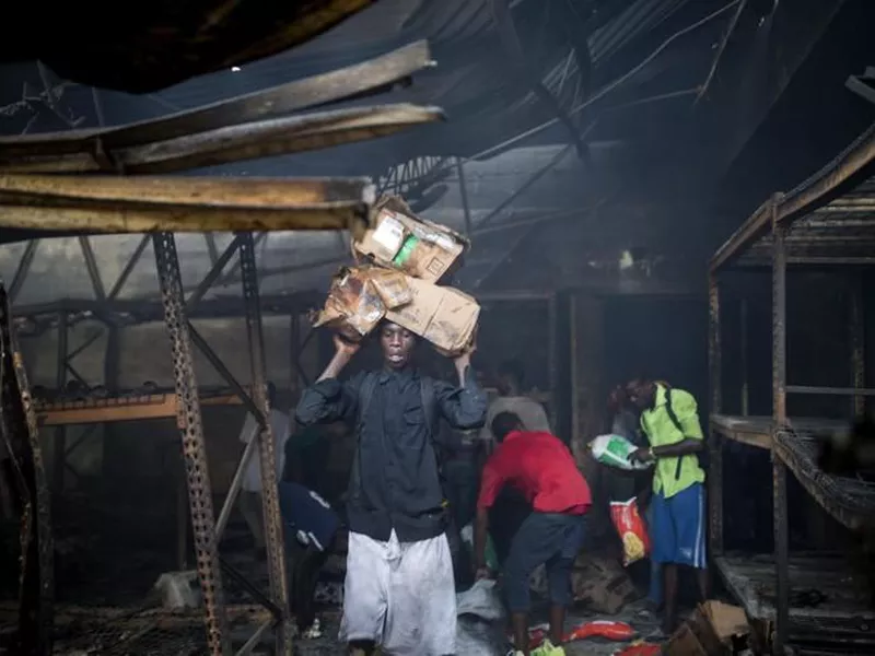 People look for usable merchandise to take from a burned Delimart store, in
Port-au-Prince, Haiti.
