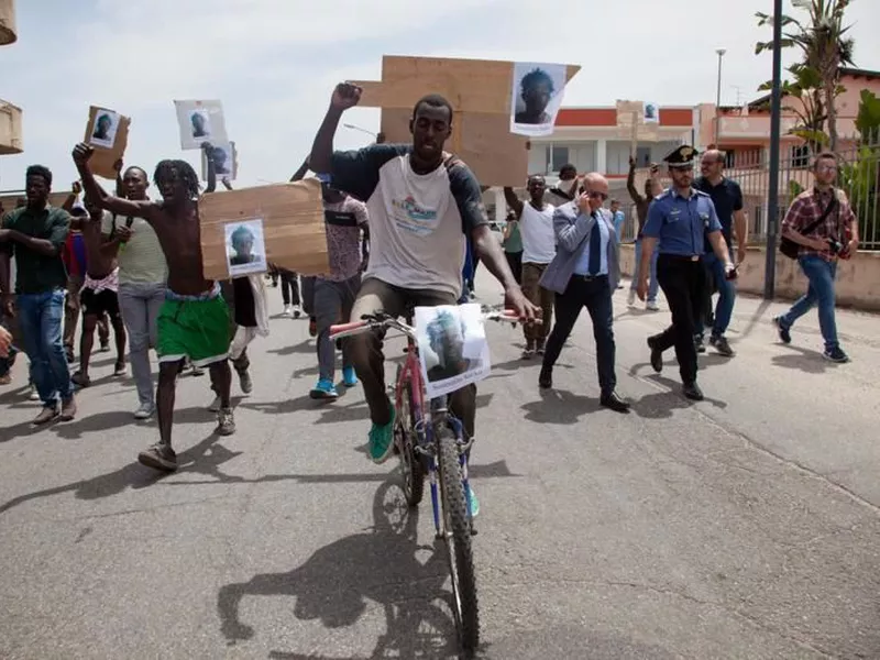 Migrants show pictures of Soumaila Sacko during a protest in San Ferdinando, Italy. Sacko, 29 years-old from Mali, was killed Saturday, June 2, during a shooting Italian investigators said.