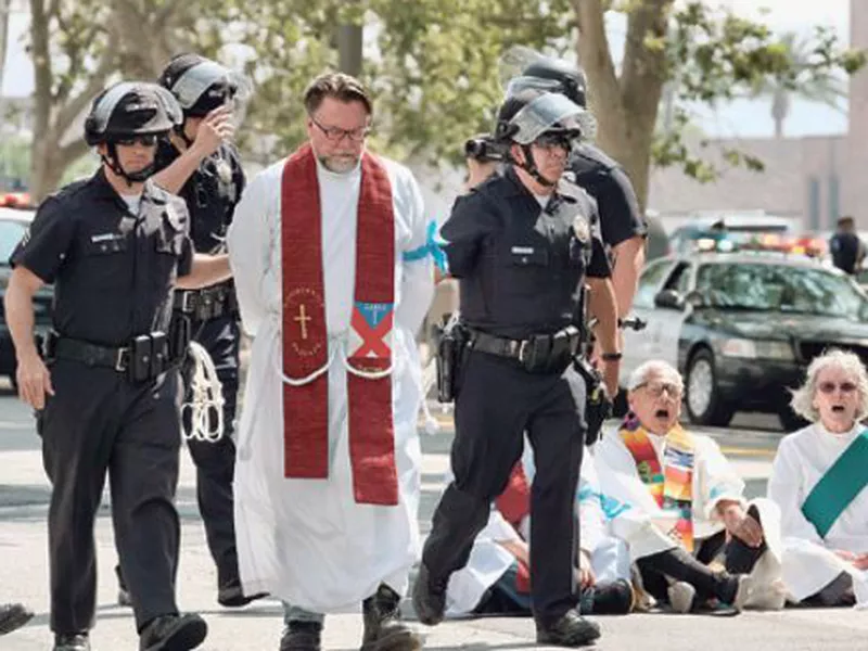A clergy member is arrested during a civil disobedience protest in front of Federal Courthouse in Los Angeles. (AP)