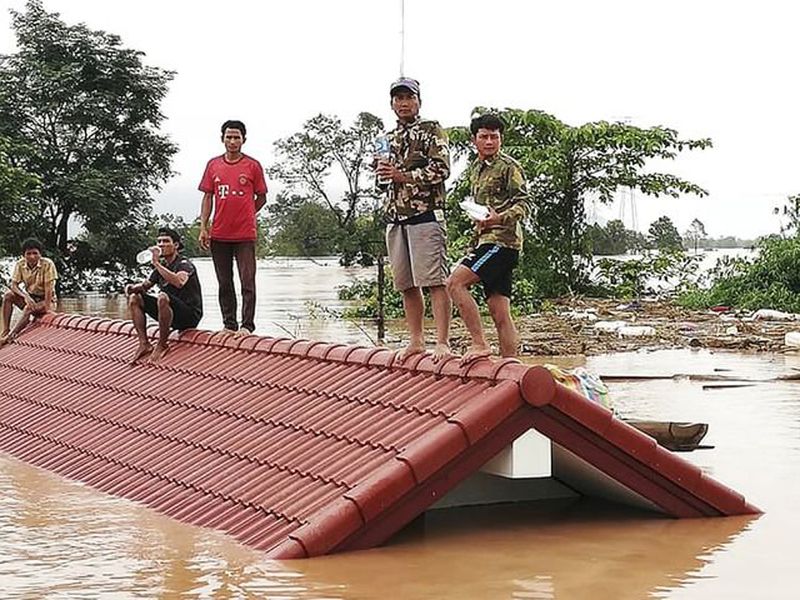 Villagers take refuge on a rooftop above flood waters from a collapsed dam in the Attapeu district of southeastern Laos.