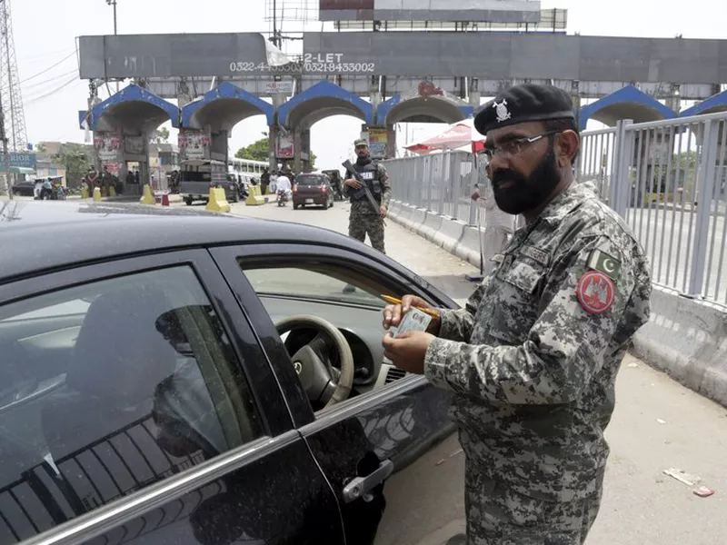 A para military soldier checks identity card of a driver enters in Lahore, Pakistan. (AP)